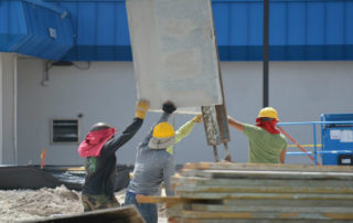 construction workers lifting concrete