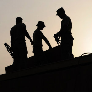 construction workers on roof silhouettes