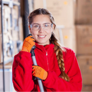 girl holding broom in warehouse