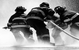 group of firefighters spraying hose