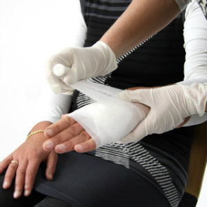 injured woman getting hand bandaged