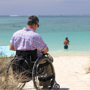 man in wheelchair on beach