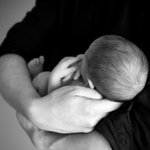 newborn cradled in arms