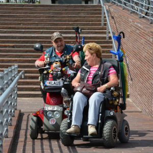 older couple in motorized wheelchairs