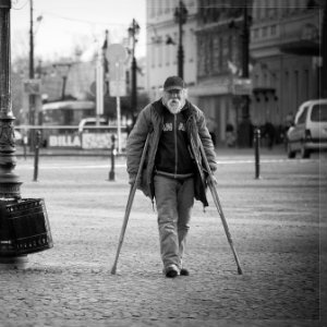 older man walking with crutches