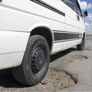 white van in pothole