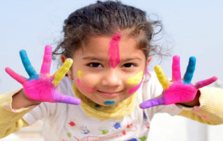 young girl with paint on hands